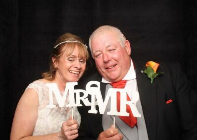 Happy bride and groom smile in the photo booth